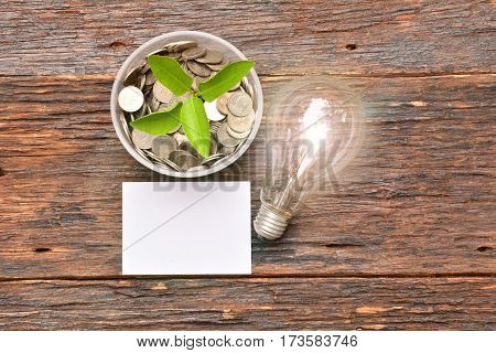 White paper mock uplight bulb for idea and stack coins in glass for save money and financial tax season