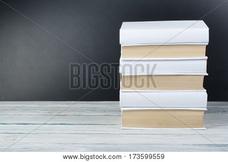 Open black and Whitel books on wooden table black board background. Back to school. Education business concept