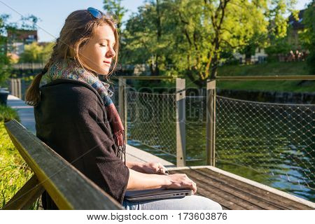 Young and attractive woman meditating with closed laptop. Feeling free.