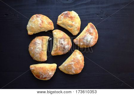 Homemade buns stuffed with jam on a black wooden background