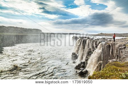 Beautiful View Of Woman Standing Near Famous Selfoss Waterfall In Vatnajokull National Park, Northea