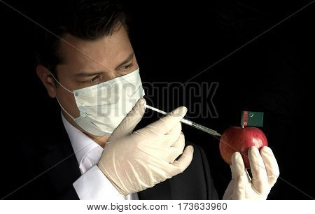 Young Businessman Injecting Chemicals Into An Apple With Turkmenistani Flag On Black Background