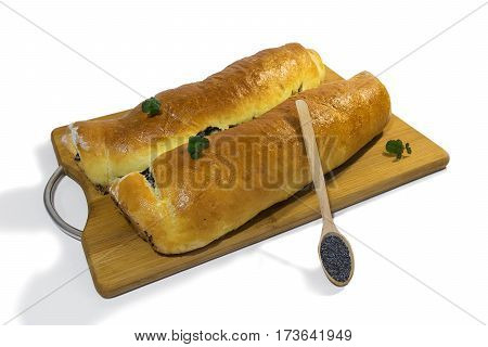 Poppy roll baked at home with sprigs of mint on a wooden board with a wooden spoon filled with grains of poppy whith shadows. Isolated on white background.