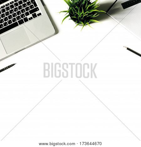White office desk frame with laptop keyboard and supplies. Laptop, notebook, pen, clips, pencil and office supplies on white background. Flat lay, top view, mockup