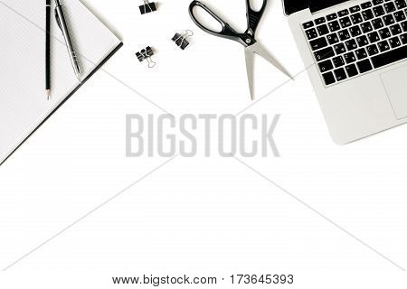 White office desk frame with laptop keyboard and supplies. Laptop, notebook, pen, clips, pencil and office supplies on white background. Flat lay, top view, mockup