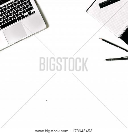White office desk frame with laptop keyboard and supplies. Laptop, notebook, pen, clips, pencil and office supplies on white background. Flat lay, top view, mockup