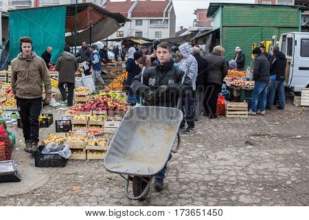 GJILAN - GNJILANE KOSOVO - JANUARY 02 2016: Young men selling fruits and vegetables in the local fresh market