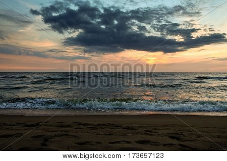 late in the evening on the sea, dark, beautiful landscape with sea waves and dark sky with bright orange stripes, cloudy, skyline, night, vespertine, extramural, afterdark