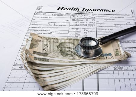 Health insurance form with indian money or currency notes of 500 and 2000 rupees and stethoscope concept for life planning
