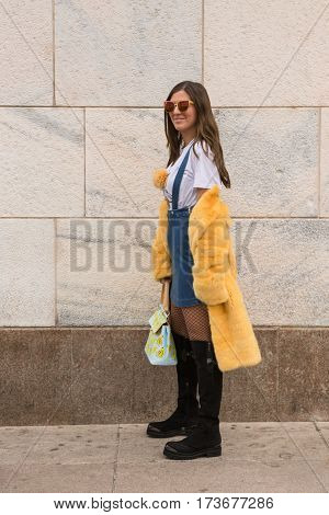 MILAN ITALY - FEBRUARY 23: Fashionable woman poses outside Genny fashion show during Milan Women's Fashion Week on FEBRUARY 23 2017 in Milan.