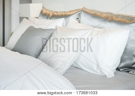 Gray Color Scheme Pillows Setting On Bed With Satin Finished Style Bedding