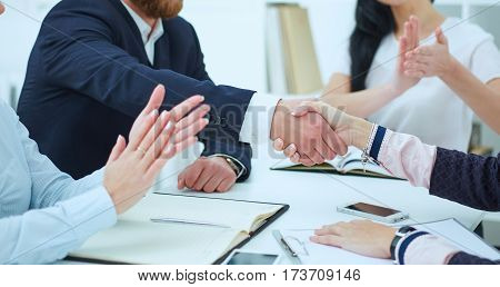 Male and female handshake in office. Serious business and partnership concept. Partners made deal sealed with handclasp.
