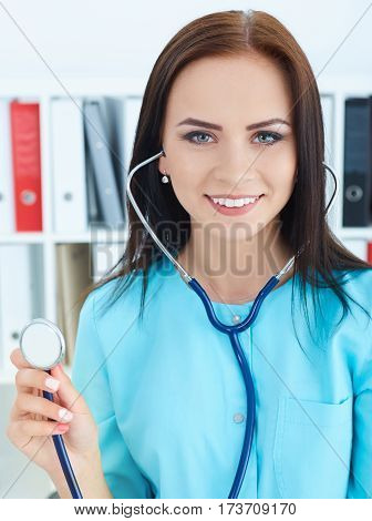 Close-up portrait of doctor with stethoscope in hand. Health insurance concept.