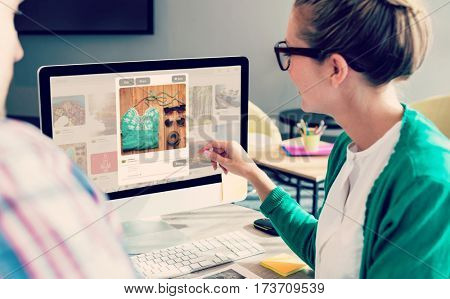 Composite image of website page blog against business people discussing over computer monitor