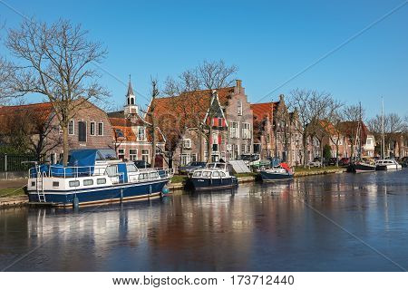 EDAM, NORTH HOLLAND/ THE NETHERLAND - JANUARY 16, 2017:  Houses along the frozen canal on one of the central streets in winter