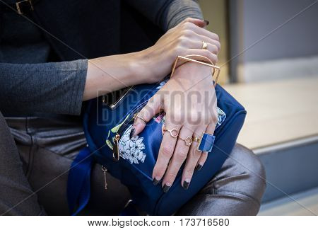 woman hands with fau bijou on blue back pack