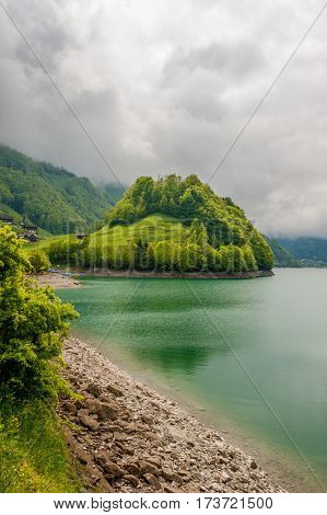 Beautiful emerald mountain lake Lungern in Switzerland under low clouds