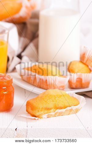 Breakfast with plumcake and orange juice on white dish.