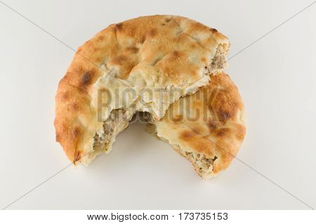 piece of khachapuri with meat lying on a white table
