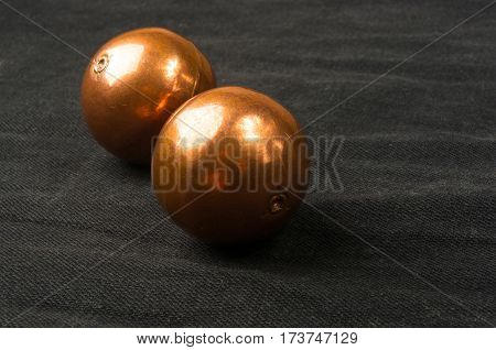 pair of copper Chinese singing balls Baoding of health for hands on black background