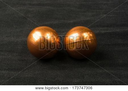 pair of copper Chinese singing balls Baoding of health for hands on black background