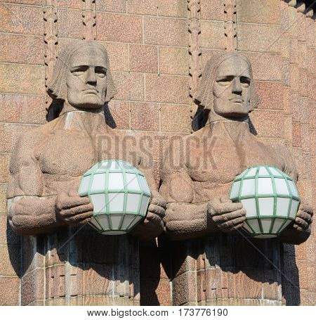 HELSINKI FINLAND SEPTEMBER 25 2015: Statues holding the spherical lamps at the Helsinki Central railway station is a widely recognised landmark in Kluuvi, part of central Helsinki