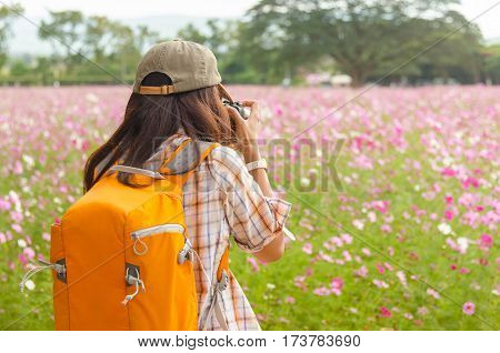 The young woman nature photographer taking pictures in the garden