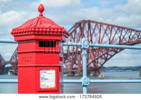 Red letterbox and Firth of Forth rail bridge in Edinburgh, Scotland UK