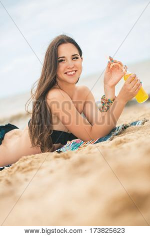 Beach woman drinking cold drink beverage having fun at beach party. Female babe in bikini enjoying orange water from glass boutle. summer concept