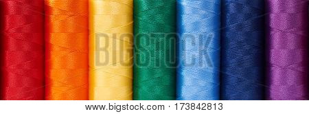 Multicolored sewing threads arrange like rainbow background