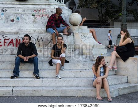 BELGRADE SERBIA - AUGUST 2 2015: People (young girls boys and an old man) waiting on Republic Square under the iconic horse Statue (Kod Konja)