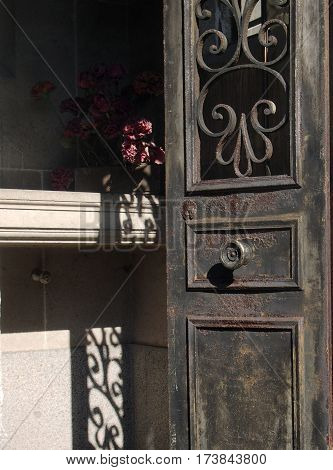 Rusted Door To Tomb With Flowers At Pere Lachaise Cemetery France