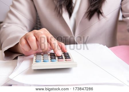 Finger accountant pressing on calculator in office