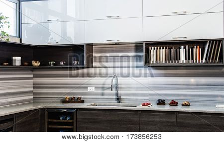 Perspective view of a modern kitchen, modern style of flat kitchen doors, brown slab cabinets of modern kitchen, granite counter tops and modern full backsplash