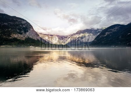 Outdoor nature of idyllic summer landscape with clear mountain lake of Hallstatt village in the Liezen District of Styria, Austria, Europe. Sunset reflection on a Hallstatter See lake in the Alps