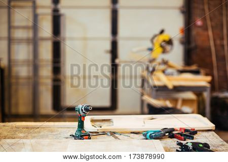Electric drill, diy-tools and wooden planks on workbench