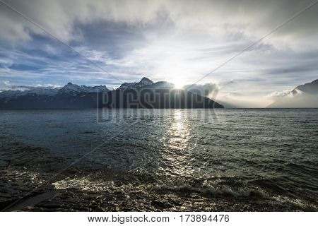 Landscape a mountain lake in the Alps. Switzerland. Sun rays over the mountain peaks.