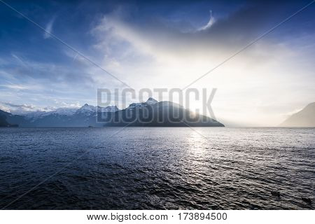 Landscape a mountain lake in the Alps. Switzerland. Sun rays over the mountain peaks.