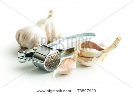 Garlic and garlic press isolated on white background.