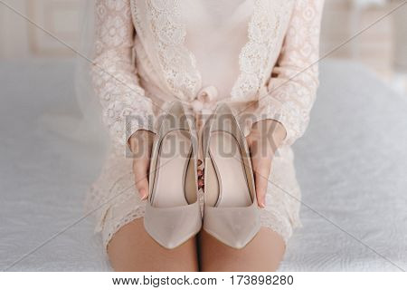 Bride puts on a beige shoes. Bride's fees.