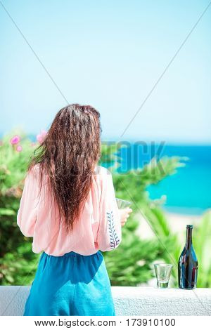 Glass and bottle of tasty red wine on balcony