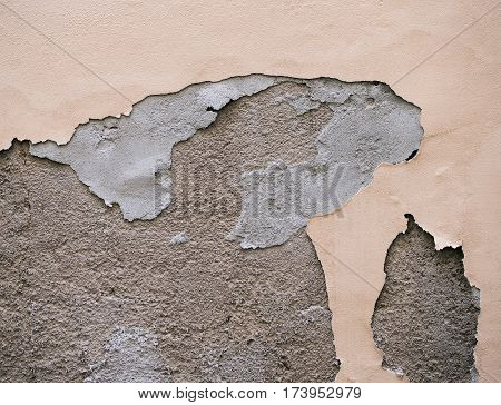 Paint is peeling off the building wall.