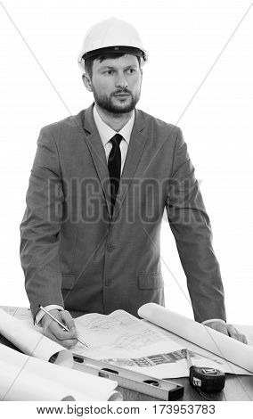Need inspiration. Black and white studio shot of a thoughtful male engineer wearing a hardhat working on his architectural blueprints businessperson brainstorming thinking profession concept