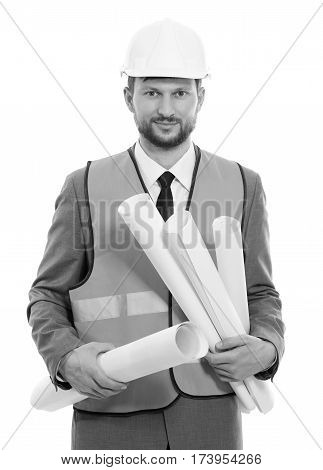 Business developer. Vertical monochrome shot of a businessman architect in a safety vest and hardhat smiling to the camera holding building project blueprints development building construction concept