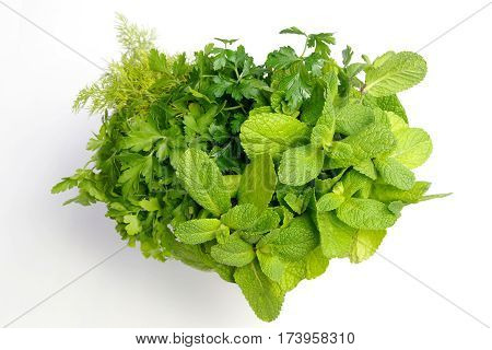 Heart-shaped bouquet of fresh green herbs and spices on white isolated background