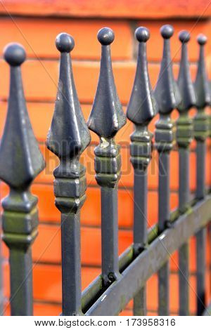 Metal heads residential fence on bricks background image