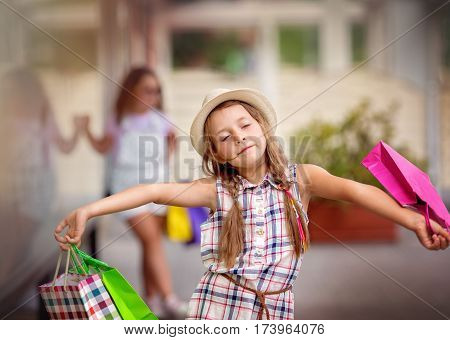cute little girl with shopping bags walking in the city
