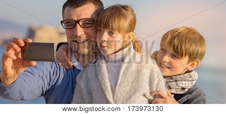 Father with his children taking selfie outdoors