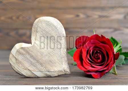 Valentines Day heart and red rose on wooden background