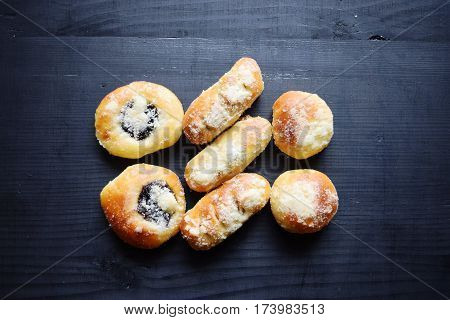 Homemade buns stuffed with jam on a black wooden background